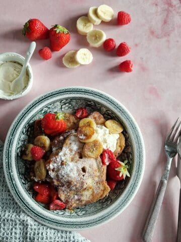 A plate with baked French toast brioche, served with mascarpone and fresh fruits.