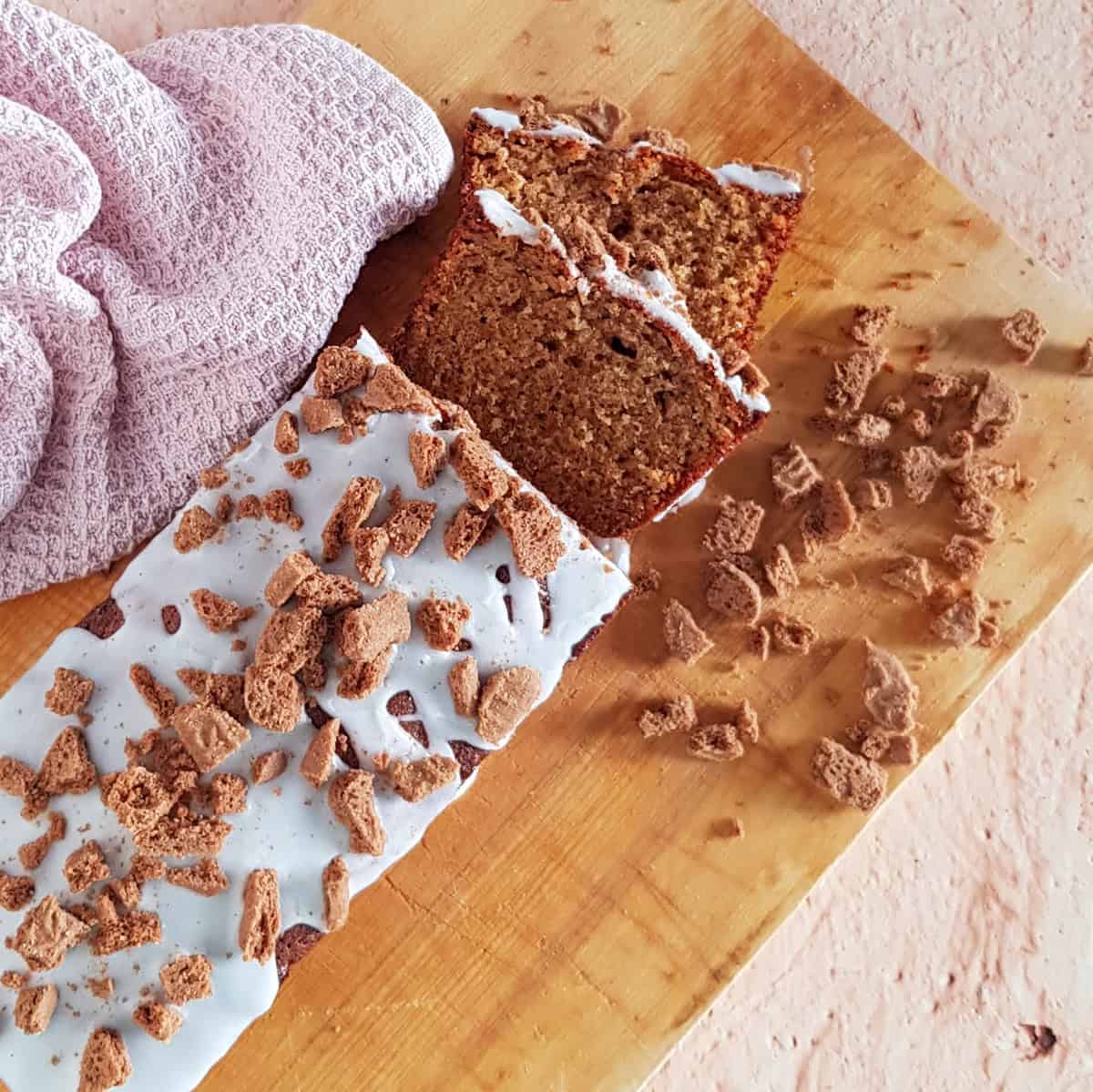 Top-view of a homemade speculaas cake, covered with a simple frosting and crumbled speculaas cookies.