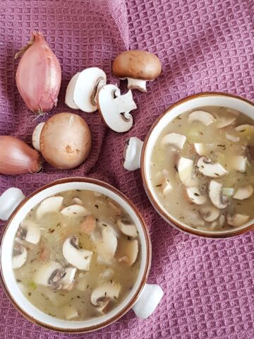 A bowl of leek mushroom soup on a purple serviet.