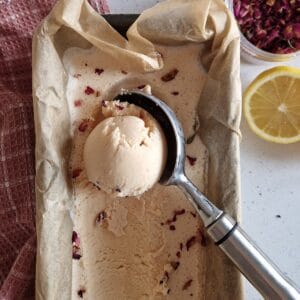 A cake tin filled with home made prickly pear ice cream. A scoop of ice cream is taken out of the tin.
