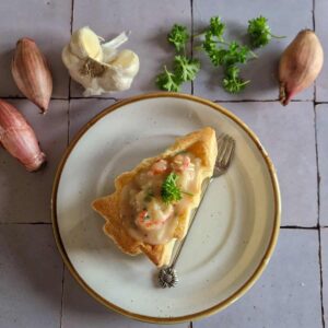 Shrimp Ragout in a Christmas Tree shaped Puff Pastry Shell, surrounded by fresh ingredients.